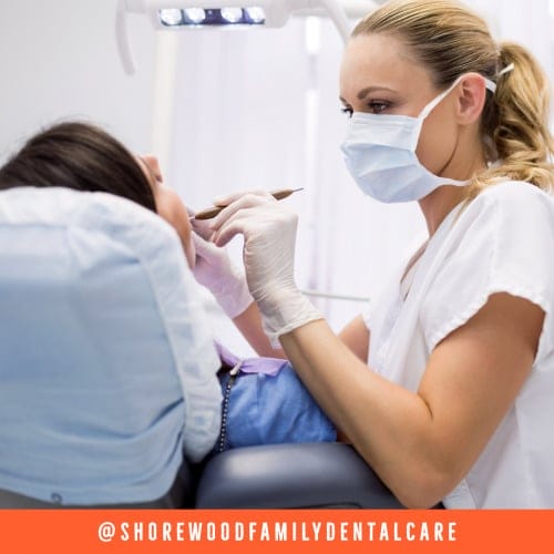 a dental hygienist cleaning a patient's teeth