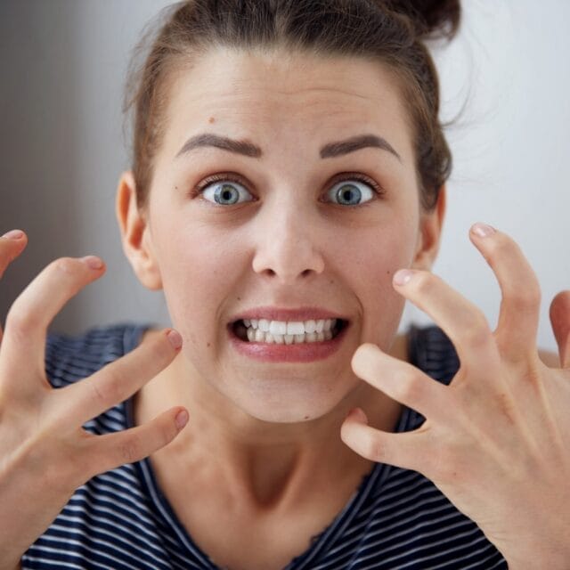 Young brunette woman in her late twenties freaking out over a canker sore